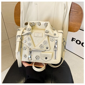 Detailed view of motorcycle jacket style crossbody bag with rhinestone flower accents