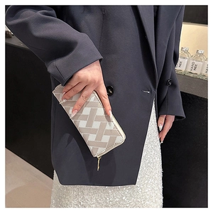 Close-up of beige and gray geometric woven pattern wallet with gold zipper detail