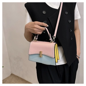 Détail du sac à bandoulière bicolore rose et bleu avec boucle dorée sur mannequin