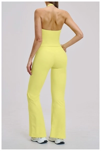 Back view of bright yellow hollow-out yoga set featuring a halter top and flared pants