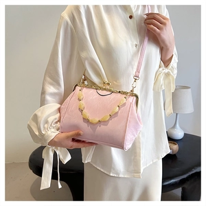 Detail of pink shell-shaped evening bag with pearl beaded handle and golden kiss-lock clasp