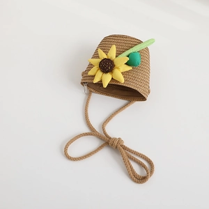 Detail view of a cute children's mini woven straw bag featuring a sunflower decoration.