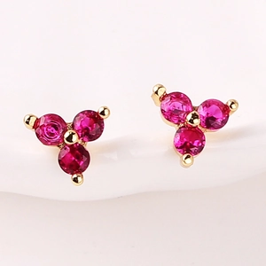 Minimalist gold stud earrings with three rose red round zircons in a floral cluster