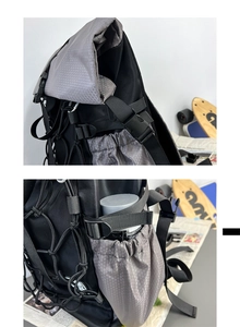 Detail of grey sports backpack showing roll-top buckle and honeycomb texture fabric