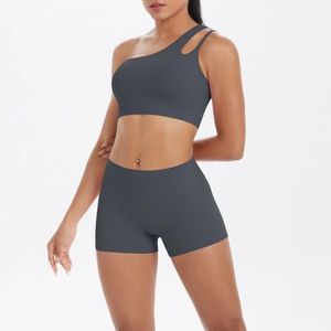 Detail of dark gray one-shoulder yoga bra and high-waist shorts set with cutout design
