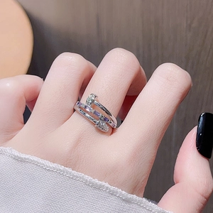 Macro detail of silver nail ring with purple and white zircon stones on woman hand