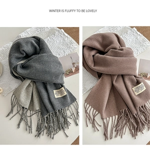 Detailed view of thick knit winter scarves with fine tassels in dark grey and tan colors