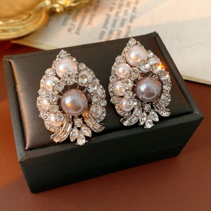 Macro shot of vintage silver earrings with inlaid pearls and sparkling rhinestones