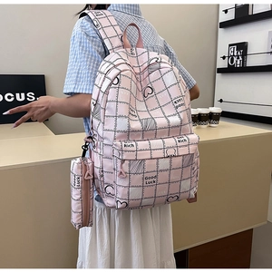 Detail of pink plaid school backpack with cute bunny patterns and a matching small pouch