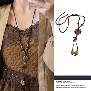 Detail of bohemian wax rope necklace with colorful beads and vintage pendant