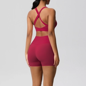 Detail of cross-back yoga bra and high-waist shorts in deep rose red fabric