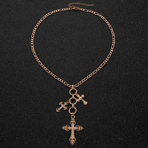 Close-up of golden multi-layered necklace with rhinestone cross and pearl charms