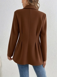 Détails de la coupe ajustée au dos et de l'ourlet plissé sur ce blazer en laine chic