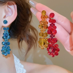 Detail showing crystal flower tassel earrings in vibrant blue, gold and red colors