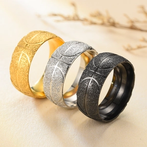 Detalle macro de anillos con textura de baloncesto en acero mate oro, plata y negro