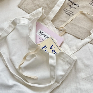 Detailed view of a minimalist white canvas tote bag showing its large internal capacity