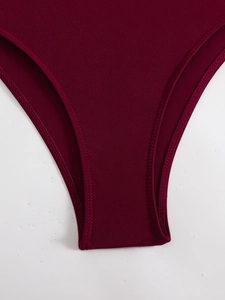 Gros plan de l'entrejambe d'un maillot de bain bordeaux avec coutures à double aiguille
