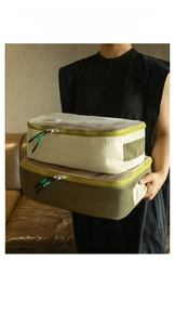Detail of travel packing cubes in beige and olive green with breathable mesh and sturdy handles