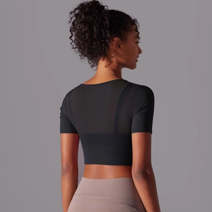 Detail view of the breathable mesh back panel on a black cropped short sleeve yoga top