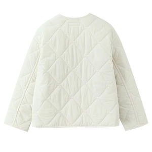 Detail of diamond quilted stitching and soft fabric texture on cream quilted jacket