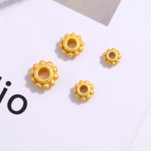 Macro detail of four gold-plated S925 silver flower spacers with a matte frosted texture