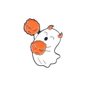 Broche fantôme d'Halloween en émail avec cornes oranges et pompons sur fond blanc