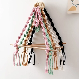 Detail of bohemian hand-woven cotton ropes and natural wood rod for wall tissue holder
