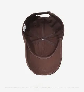 Detailed interior view of a distressed brown baseball cap with cross reinforcement and tags
