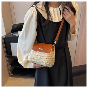 Detail of woven straw handbag featuring brown leather flap and gold-tone twist lock closure