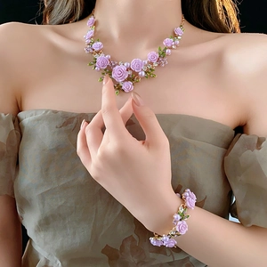 Détails d'un ensemble collier et bracelet avec roses mauves, perles et cristaux