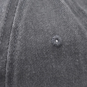 Macro detail of charcoal grey washed cotton baseball cap with ventilation eyelet and stitching