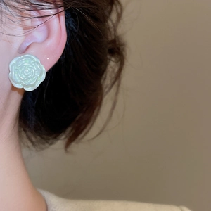 Detailed view of the pearlescent white rose petal earring worn for a vintage look