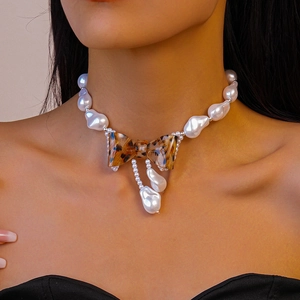 Detailed close-up of a leopard print bow pendant on an irregular faux pearl necklace
