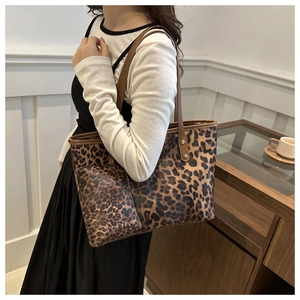 Detail of leopard print tote bag with matching pouch shown in a modern interior setting