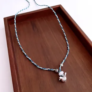Collier corde en coton bleu tissé à la main avec pendentif oiseau argenté sur bois