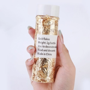 Detailed view of a 2g bottle of edible gold flakes for cake decorating and DIY crafts