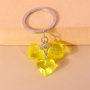Close-up of yellow resin heart charms on a polished silver metal keychain ring