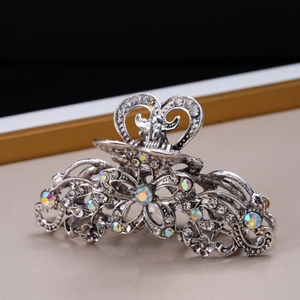 Detail view of vintage silver hair claw clip with rhinestones and floral pattern