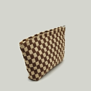 Detailed macro view of the brown checkerboard knit makeup bag with zipper closure