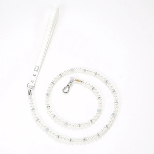 Detailed view of pearl pet leash with silver metal buckle and white leather handle strap