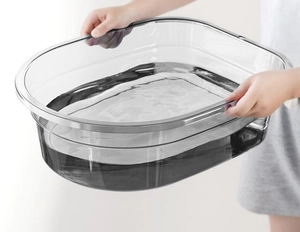 Detailed close-up of a large transparent plastic washbasin showing its depth and clarity
