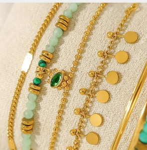 Detail of bohemian gold link chains with light green natural stone beads and small pendants