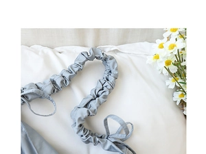 Detail of the grey-blue nylon bag featuring a unique pleated shoulder strap and soft fabric