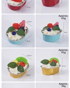 Vue détaillée de cupcakes aux fruits artificiels en caissettes colorées avec garnitures