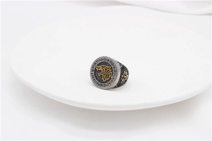 Macro shot of Viking wolf head relief and Nordic runes on a vintage steel ring