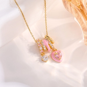 Gold multi-pendant necklace with pink crystal hearts and enamel charms on white silk