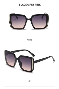 Detail view of square frame sunglasses with black frames and gradient grey-pink lenses