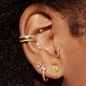 Close-up of golden S925 sterling silver curved wave hoop earrings set with zircon stones