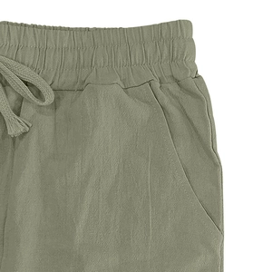 Detail of linen trousers with elastic drawstring waist and pockets in olive green