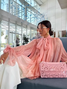 Fashionable pink long sleeve sheer blouse with flowing ribbons and loose casual silhouette